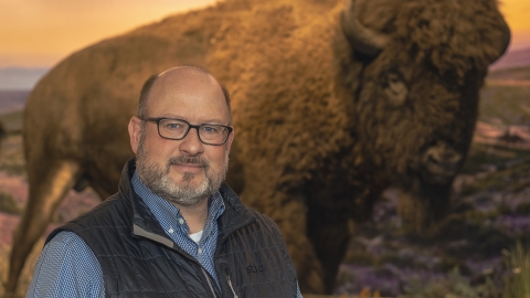 BU Magazine 2024 Spring Alumni -Mark Cool ’91 in front of a wild bison picture