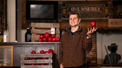 Ben Fink tosses an apple in his right hand at Civil War Cider.