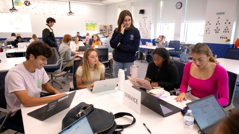 MGMT 101 students work together around a table.