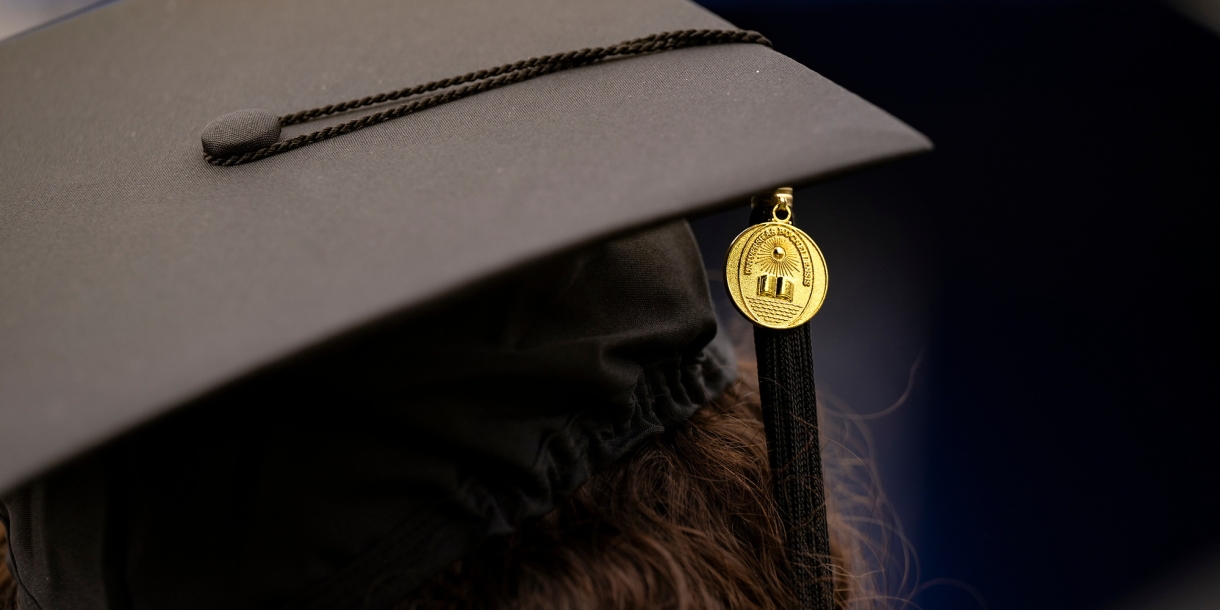 A close-up photo of a graduation cap with a Bucknell medallion and tassel