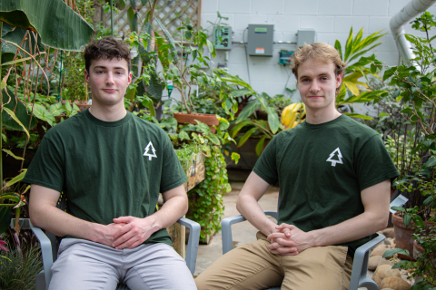 Ben Suit '27 (L) and Zack Yardley '25 (R) - Third Place $2,500 - Forevergreen, sitting on chairs in front of plants