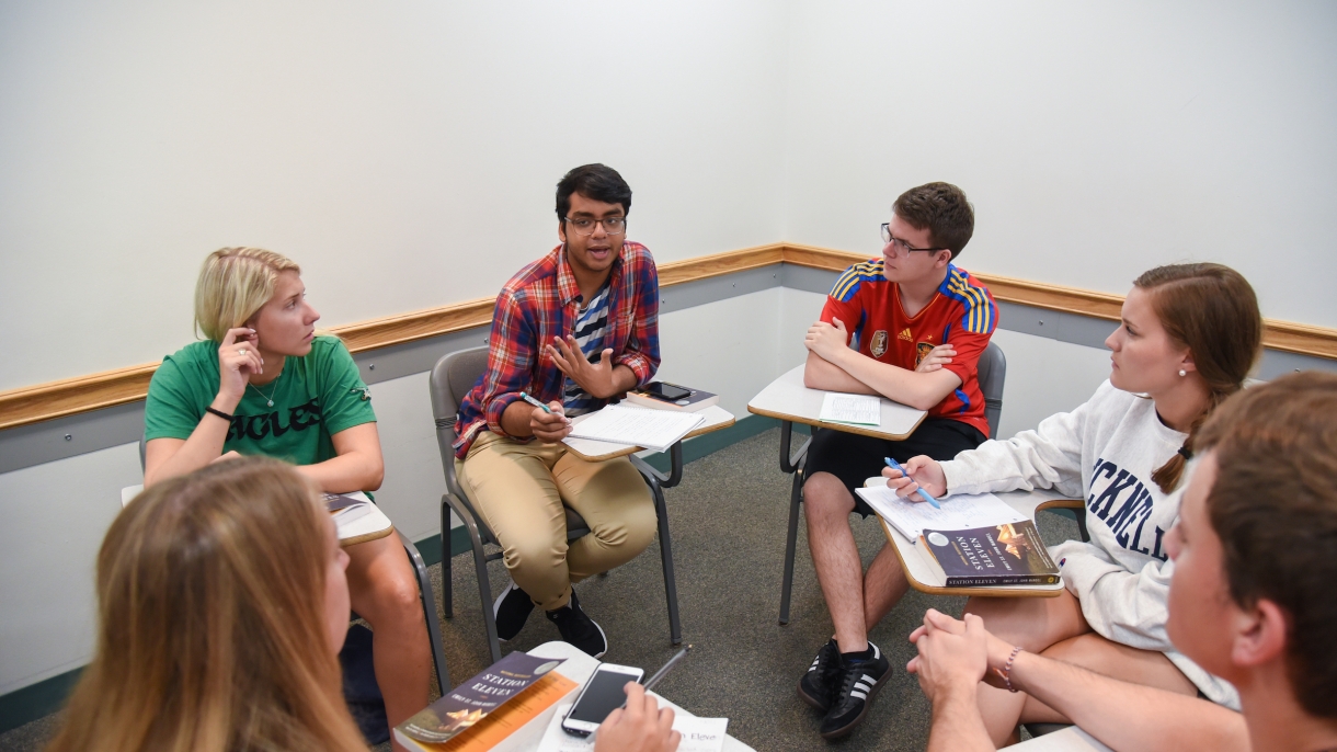 Students in a circle of desks discuss the first-year common reading book.