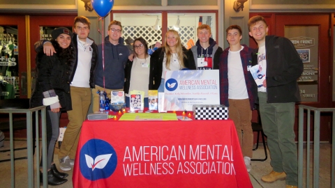 The management 101 group stands behind a table at the Lewisburg Stroll Through the Arts Festival in Lewisburg