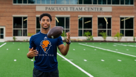 Chris Sims tossing a football on the field.