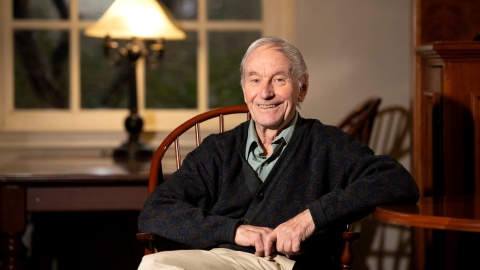 David Fletcher sits in a chair in a library.