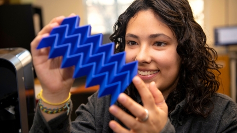 Iona Pitkin &#039;25 looks at a plastic plate with 3D zig-zag design.