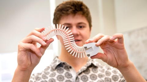 Caiden Covell '25 bends the spine of his robot