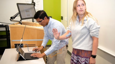 Faculty memeber and student with electrodes on student's arm