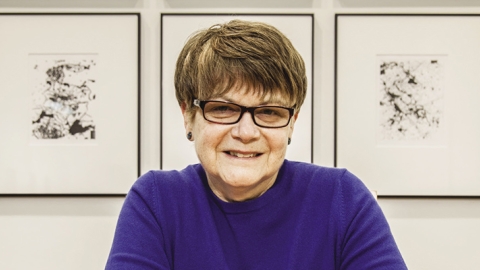 Headshot with three paintings in the background