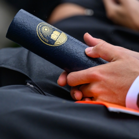 a student holds their diploma.