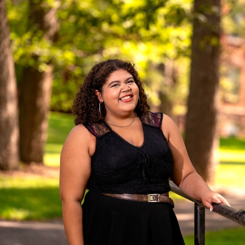 Kaylin Reynolds poses, smiling, in a black dress