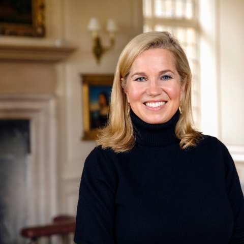 Jessica Livingston smiles in front of a fireplace