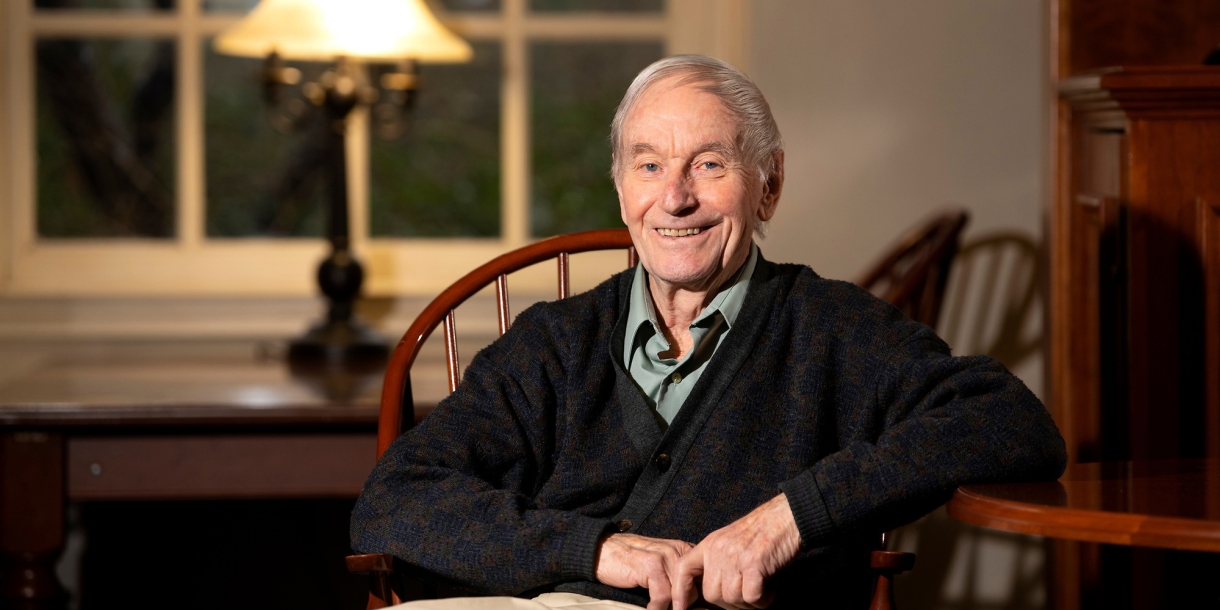 David Fletcher sits in a chair in a library.