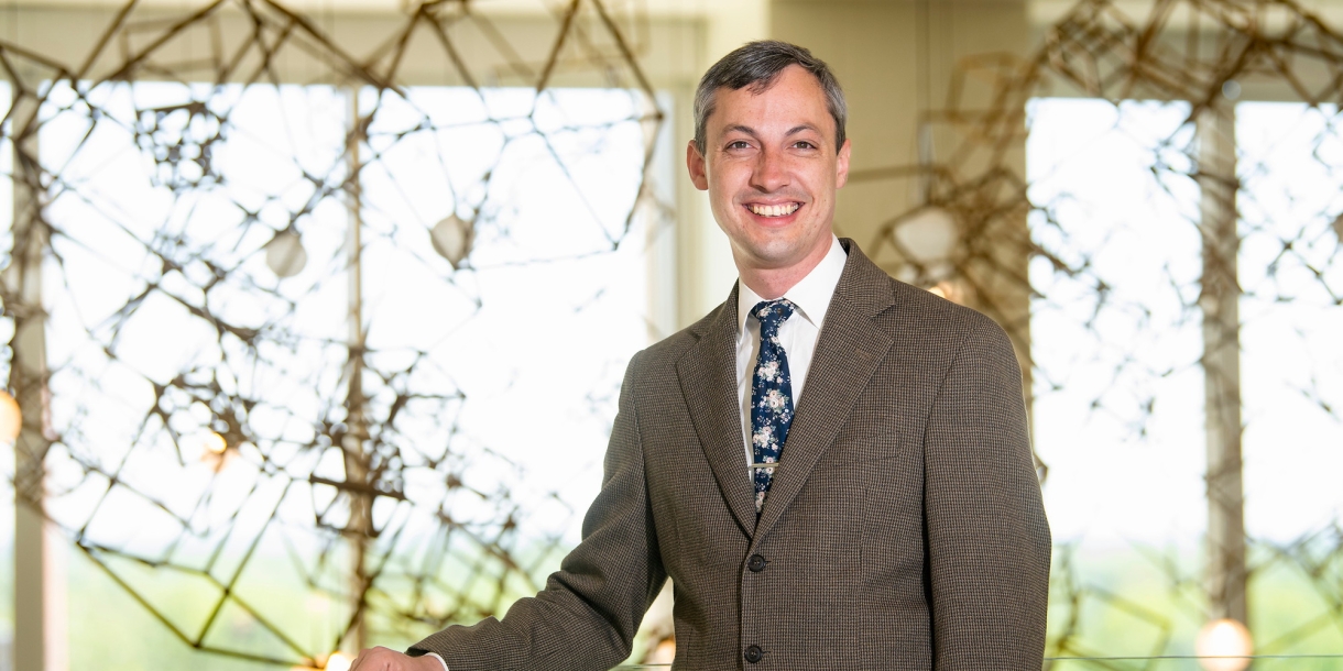 Daniel Street wears a brown suit and smiles