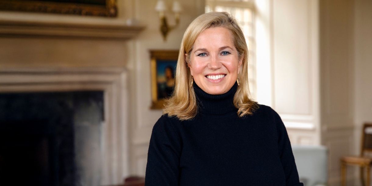 Jessica Livingston smiles in front of a fireplace