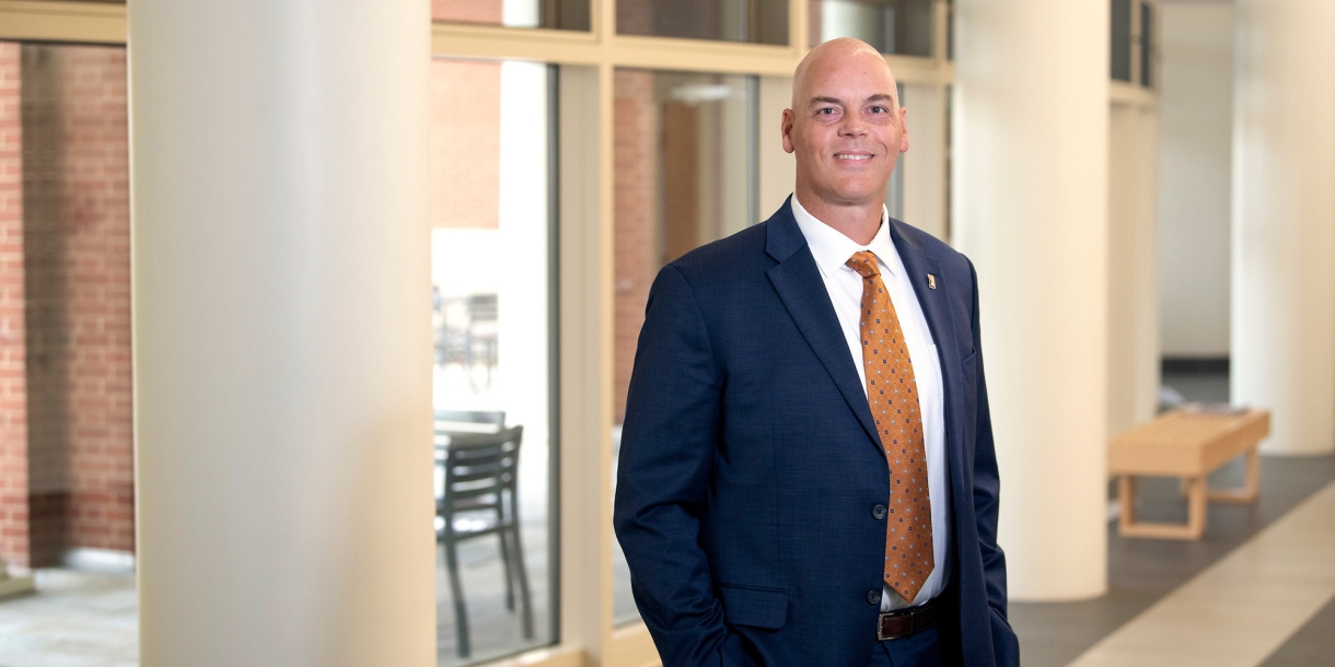 Portrait of Brad Putman in a suit inside Academic East