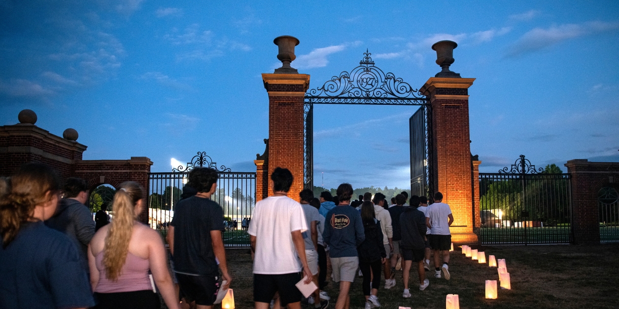 Students enter the Christy Matthewson Gates at twilight