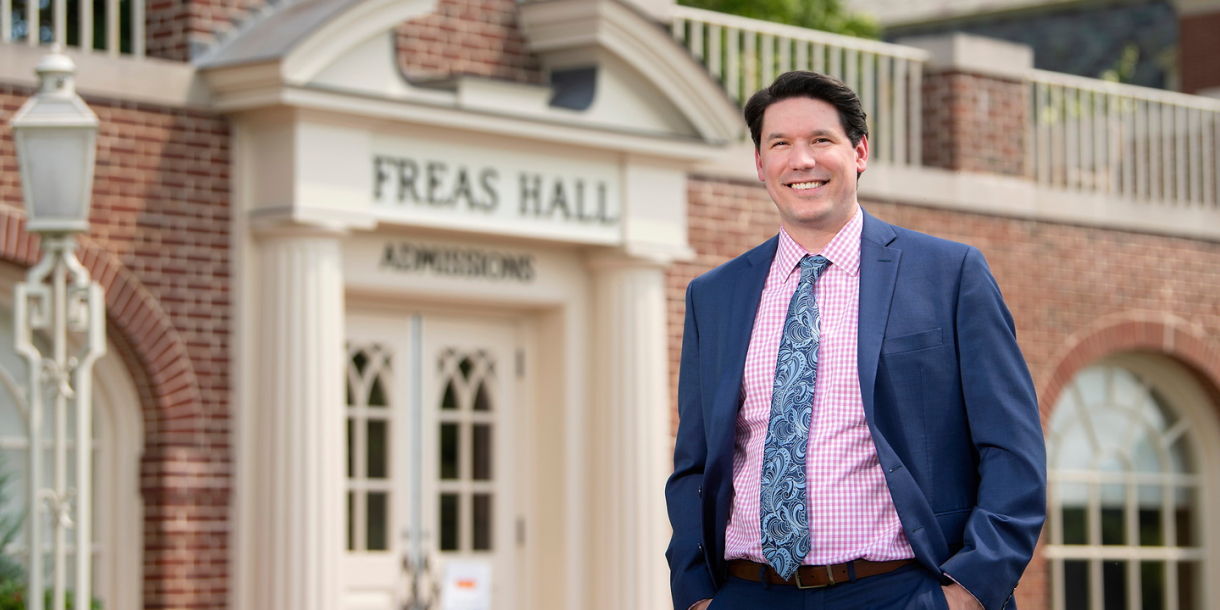Kevin Mathes in front of Office of Admissions