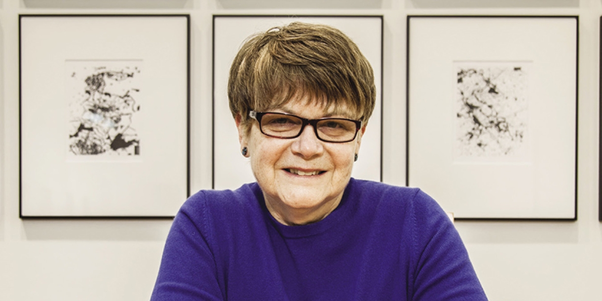 Headshot with three paintings in the background