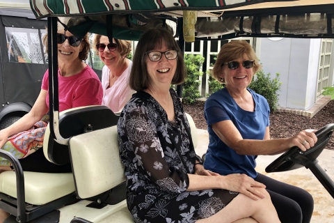 Mary Ellen Darcy Austin ’79, Mary Jaccodine ’79, Pat Nowak Debski ’79, Allie Blair Spencer ’79, M’79 sit in a golf cart together and smile.