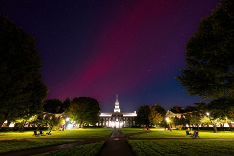 A red streak of color paints the night sky over a lit-up Malesardi Quadrangle.