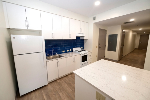 Kitchen with white cabinets and blue backspash tile