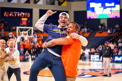 Alex Rodriguez smiles and holds Owen Garwood '27 up in the air on the Bison basketball court as Jordy Leiser and Marc Lore look on with huge smiles.