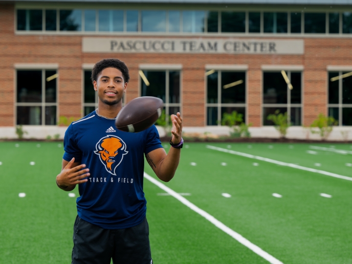 Chris Sims tossing a football on the field.