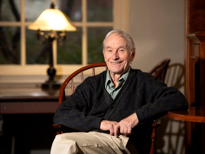 David Fletcher sits in a chair in a library.