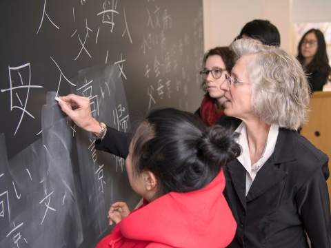 Elisabeth Armstrong writing on a chalkboard