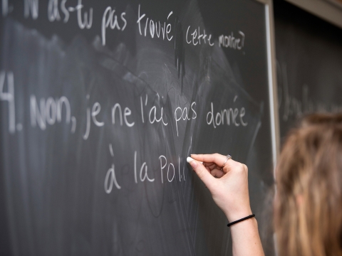 Student writing on the board in French class