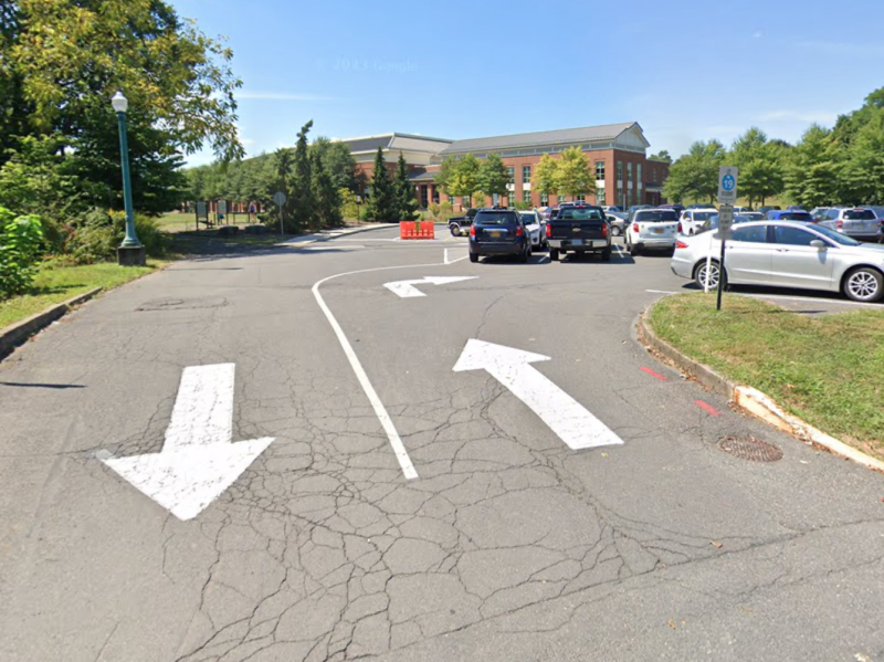 Street view of the entrance to the Bucknell shuttle pickup location. Parking lots in foreground and Graham Building in background.